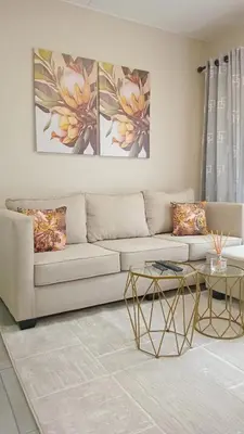 a living room with a couch and a table at Nat's Villa 2 in Midrand