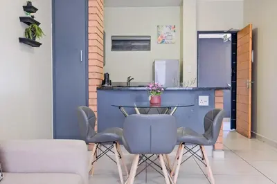 a dining room with a blue table and chairs at Nat's Villa 2 in Midrand