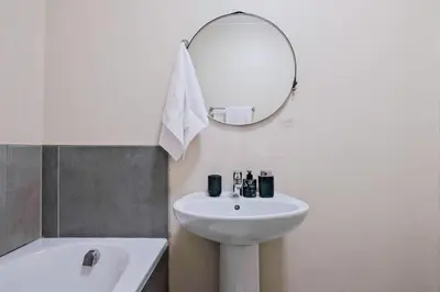 a bathroom with a sink and a mirror and a tub at Nat's Villa 2 in Midrand