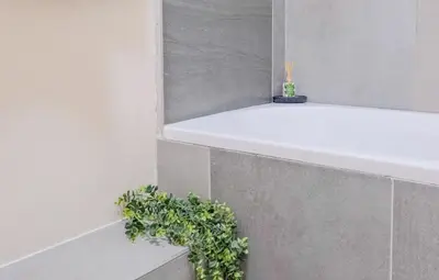 a bathroom with a white tub and a plant at Nat's Villa 2 in Midrand