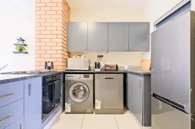 a kitchen with a washer and dryer in it at Nat's Villa 2 in Midrand