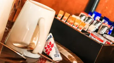 a cup and a packet of toothpaste on a table at Grand Kruger Lodge and Spa in Marloth Park