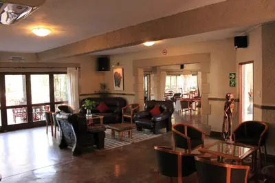 a living room with couches and chairs and tables at Grand Kruger Lodge and Spa in Marloth Park