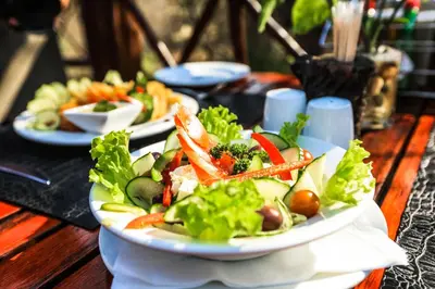 a plate of food on a table with a salad at Grand Kruger Lodge and Spa in Marloth Park