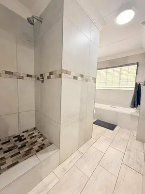 a white bathroom with a shower and a tub at Casa Della Monument Park in Pretoria