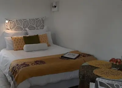 a bedroom with a bed with a book on it at Casa de Santos Bed and Breakfast Solar and Water off grid in Benoni