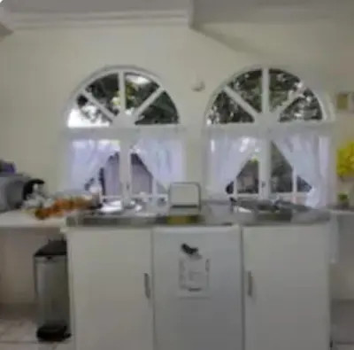a kitchen with two arched windows and a counter at Casa de Santos Bed and Breakfast Solar and Water off grid in Benoni