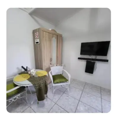 a living room with a table and a tv at Casa de Santos Bed and Breakfast Solar and Water off grid in Benoni