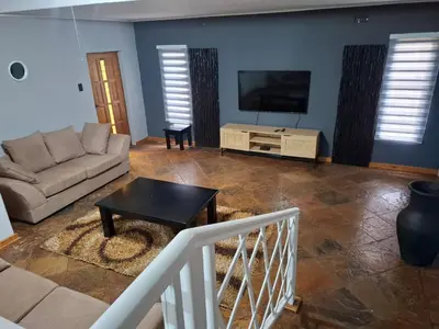a living room with a couch and a tv at Junior's inn place in Hartbeespoort