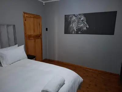 a bedroom with a bed with a lion picture on the wall at Junior's inn place in Hartbeespoort