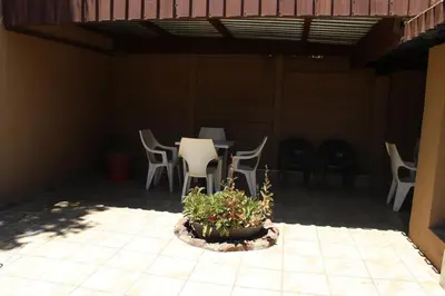 a patio with a table and chairs and a potted plant at Boitumelo Guest House in Pretoria