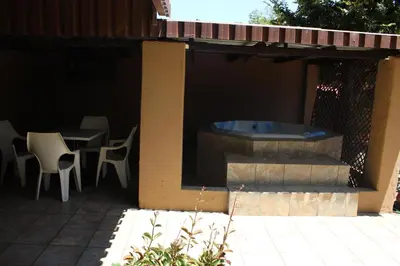 a patio with a hot tub and tables and chairs at Boitumelo Guest House in Pretoria