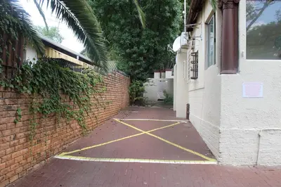 a brick alley with yellow paint on it next to a building at Boitumelo Guest House in Pretoria