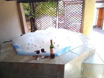 a hot tub with two glasses and a bottle of wine at Boitumelo Guest House in Pretoria