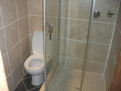 a bathroom with a toilet and a glass shower at Boitumelo Guest House in Pretoria