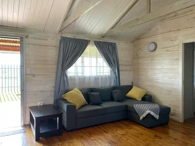 a living room with a blue couch with yellow pillows at Eindelik on de Lange in Graskop