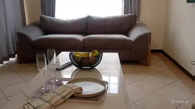 a living room with a couch and a table at Pretoria North Royal-IN in Akasia