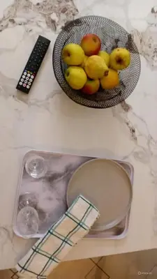 a bowl of fruit on a table with a remote control at Pretoria North Royal-IN in Akasia