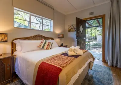 a bedroom with a bed and a window at Linger at the Lake Chrissiesmeer in Lake Chrissie