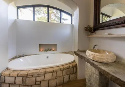 a bathroom with a large tub and a sink at Linger at the Lake Chrissiesmeer in Lake Chrissie