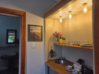 a kitchen with a sink and a mirror at Linger at the Lake Chrissiesmeer in Lake Chrissie