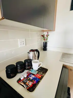 a kitchen counter with a tray of food and a coffee at Lagoon Aparthotel in Pretoria