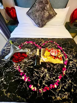 a bed with a tray of food on it at Lagoon Aparthotel in Pretoria