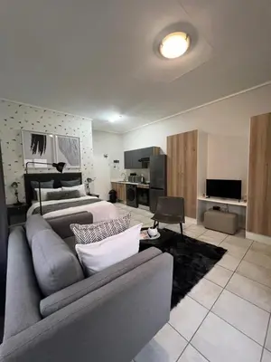 a living room with a couch and a bed at Lagoon Aparthotel in Pretoria