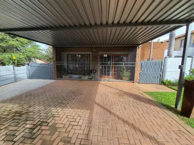 a brick patio with awning in front of a building at The Marley in Polokwane