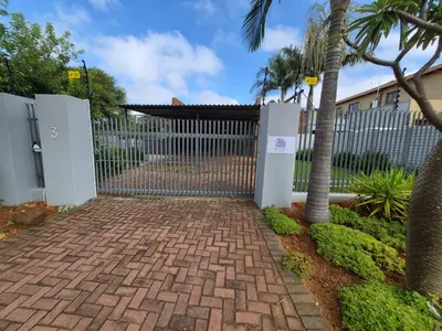 a gate with a brick walkway in front of a fence at The Marley in Polokwane
