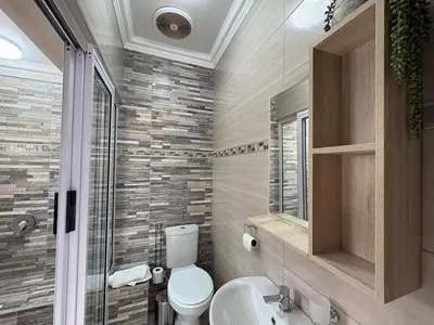 a bathroom with a toilet and a sink and a shower at The Marley in Polokwane