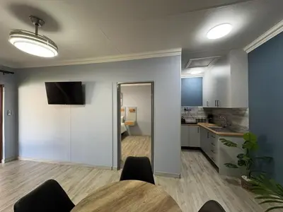 a living room with a table and a kitchen at The Marley in Polokwane