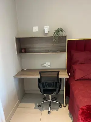a desk with a chair next to a bed at Hatfield Studio Apartment Units in Pretoria