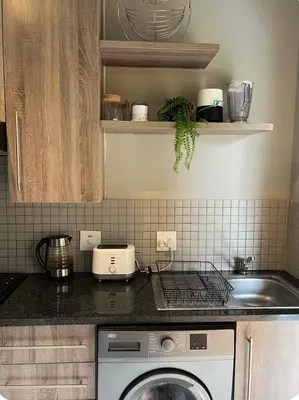 a kitchen with a washing machine and a sink at Hatfield Studio Apartment Units in Pretoria