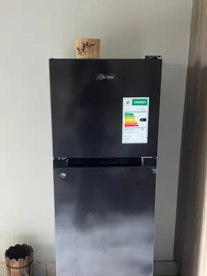 a black refrigerator with a sign on the front of it at Hatfield Studio Apartment Units in Pretoria