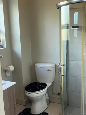 a bathroom with a toilet and a glass shower at Hatfield Studio Apartment Units in Pretoria