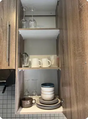 a cupboard with plates and cups and dishes in it at Hatfield Studio Apartment Units in Pretoria