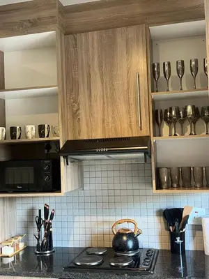 a kitchen with wooden cabinets and a stove top oven at Hatfield Studio Apartment Units in Pretoria