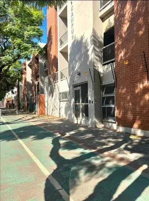 an empty street in front of a brick building at Hatfield Studio Apartment Units in Pretoria