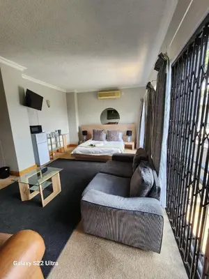 a living room with a couch and a bed at 16 Sleeper Holiday Home-Mansion in Hartbeespoort