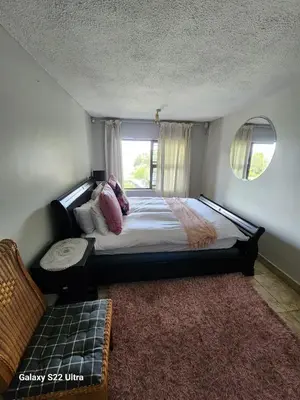 a bedroom with a large bed and a window at 16 Sleeper Holiday Home-Mansion in Hartbeespoort