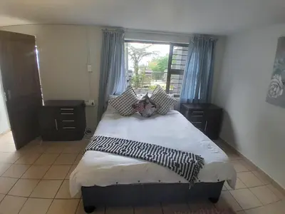 a bedroom with a large bed with a window at 16 Sleeper Holiday Home-Mansion in Hartbeespoort