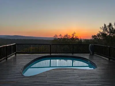a pool on a deck with the sunset in the background at Luxury Villa at Elements Golf Course - Bela Bela in Warmbaths