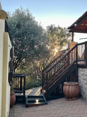a wooden staircase with a pot next to a building at Luxury Villa at Elements Golf Course - Bela Bela in Warmbaths