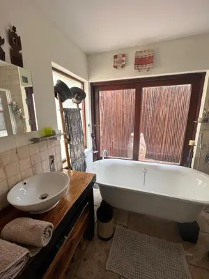 a bathroom with a white tub and a sink at Luxury Villa at Elements Golf Course - Bela Bela in Warmbaths