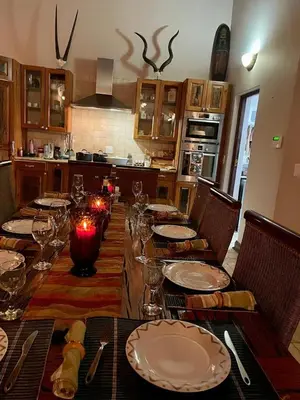 a table with plates and glasses on it in a kitchen at Luxury Villa at Elements Golf Course - Bela Bela in Warmbaths