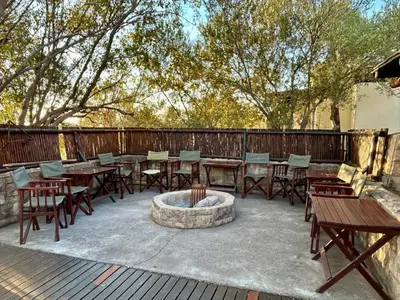 a patio with tables and chairs and a fire pit at Luxury Villa at Elements Golf Course - Bela Bela in Warmbaths