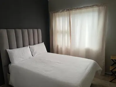a white bed with white sheets and a window at Spacious Midrand 3 Bedroom Near Gallagher, MOA & Gautrain in Midrand