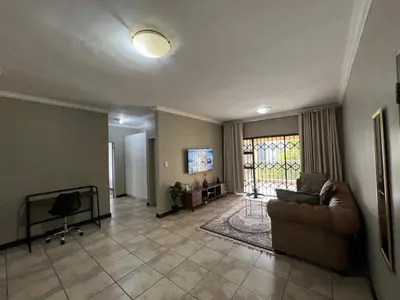 a living room with a couch and a tv at Spacious Midrand 3 Bedroom Near Gallagher, MOA & Gautrain in Midrand