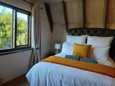 a bedroom with a large bed and a window at The Swiss Garden in Midrand